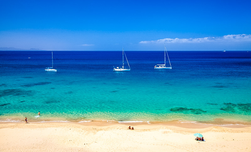 Lanzarote, white sand beaches Playas de Papagayo filling with people in the morning