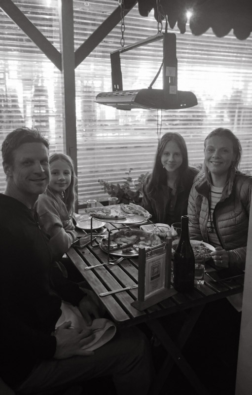 family posing at the restaurant patio table