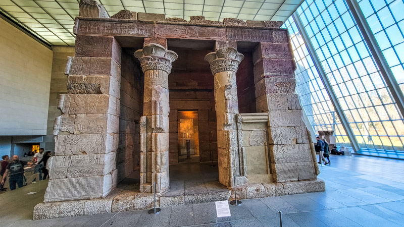 egyptian temple replica inside the met with glass walls behind it