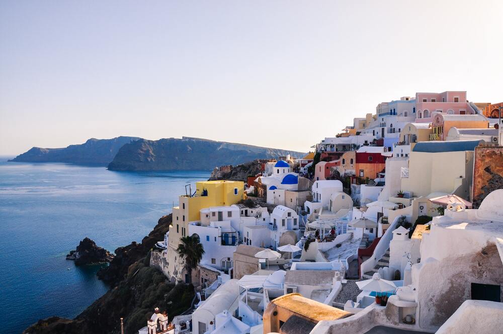 white and colorful buildings on the cliff faces of mykonos