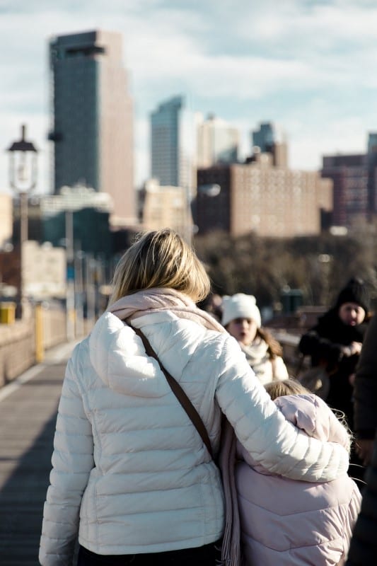 woman hugging child walking in new york city