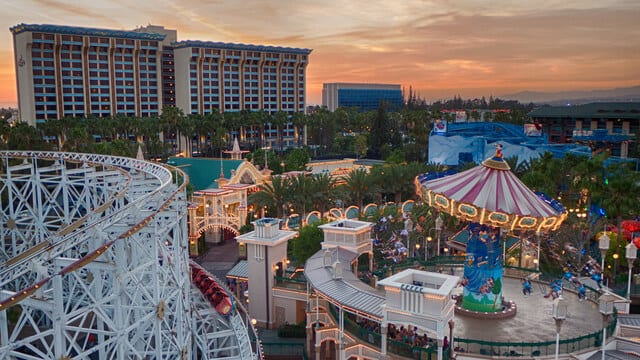 Disney's Paradise Pier Hotel with carousel and roller coaste  in front at sunset