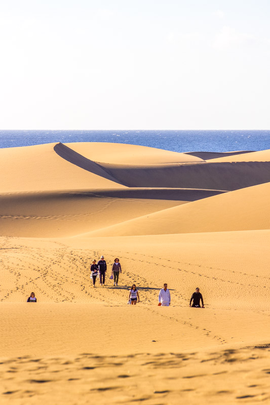 Tourists walk over the Maspalomas dunes. This is a very big area of famous dunes