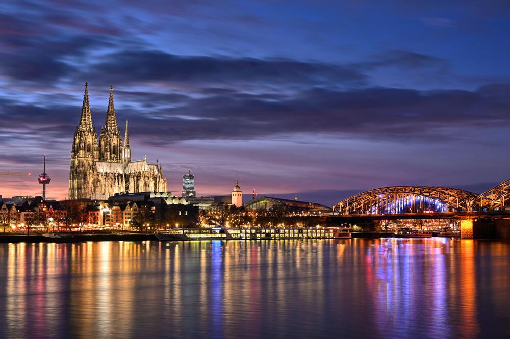 chruch  and buildings on river lit up at night