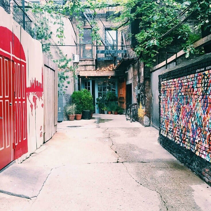 laneway with murals on wall and bikes out front of hidden cafe at Freemans