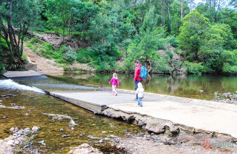 family walking across a road covered in water