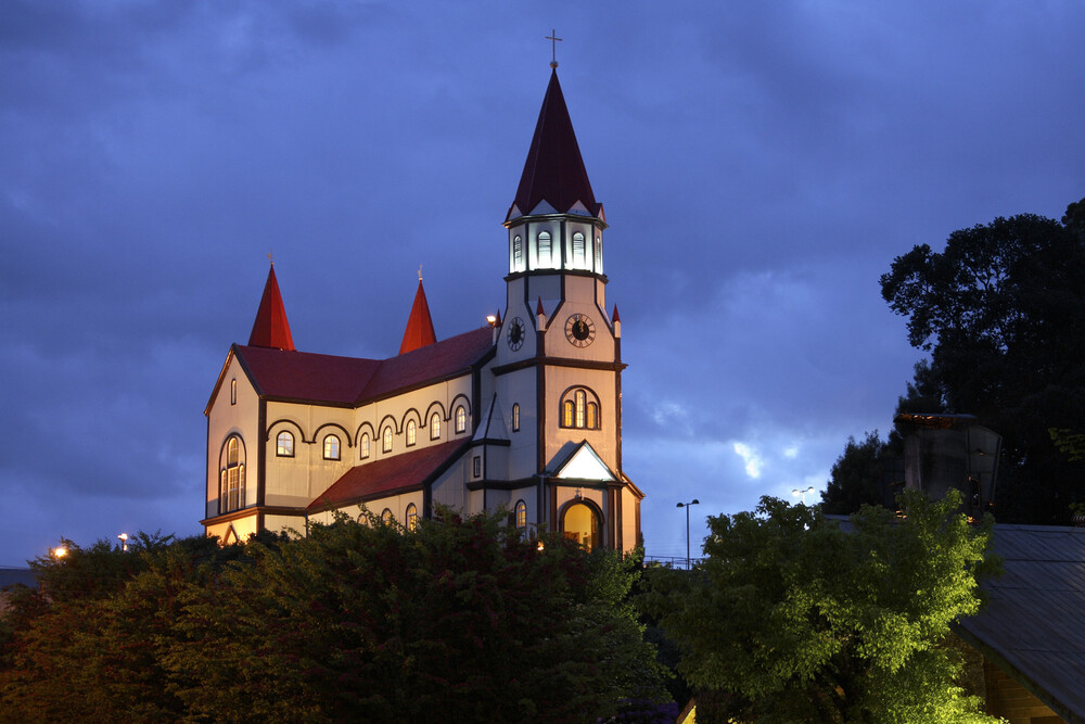 church on hill lit up at night