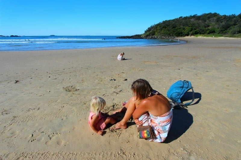 woman and a child playing on the sand