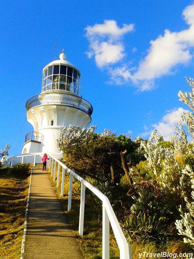 girl on path heading up to a lighthouse