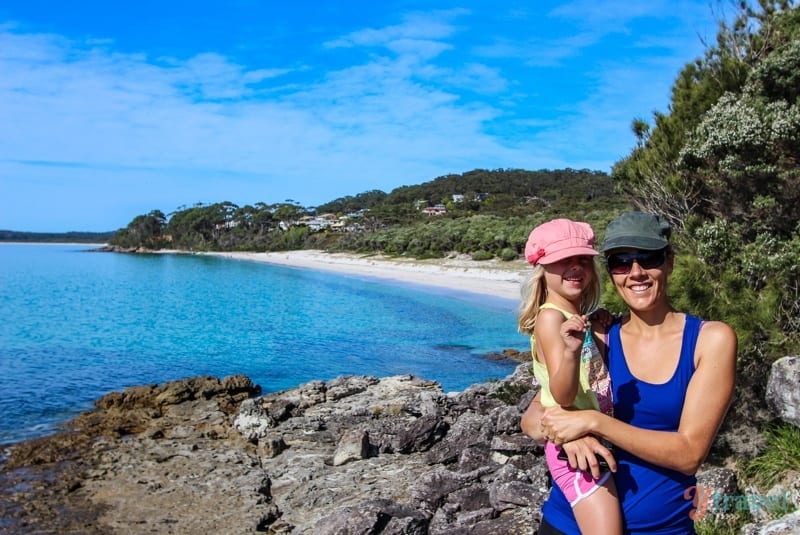 woman and child posing to camera with beach in background