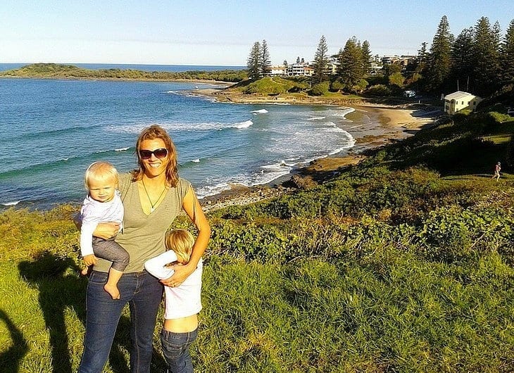 a woman and children standing on a beach lookout