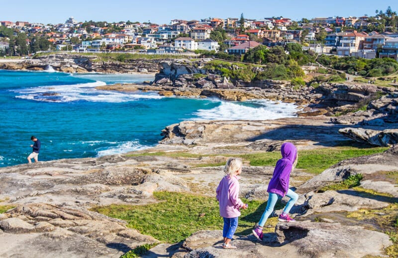  girls walking on the Bondi to Bronte coastal walk with views of the water