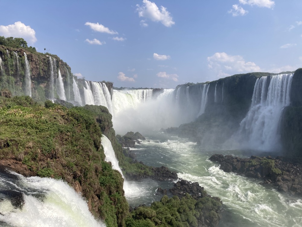 view of Iguazu Falls htundering over cliff from below