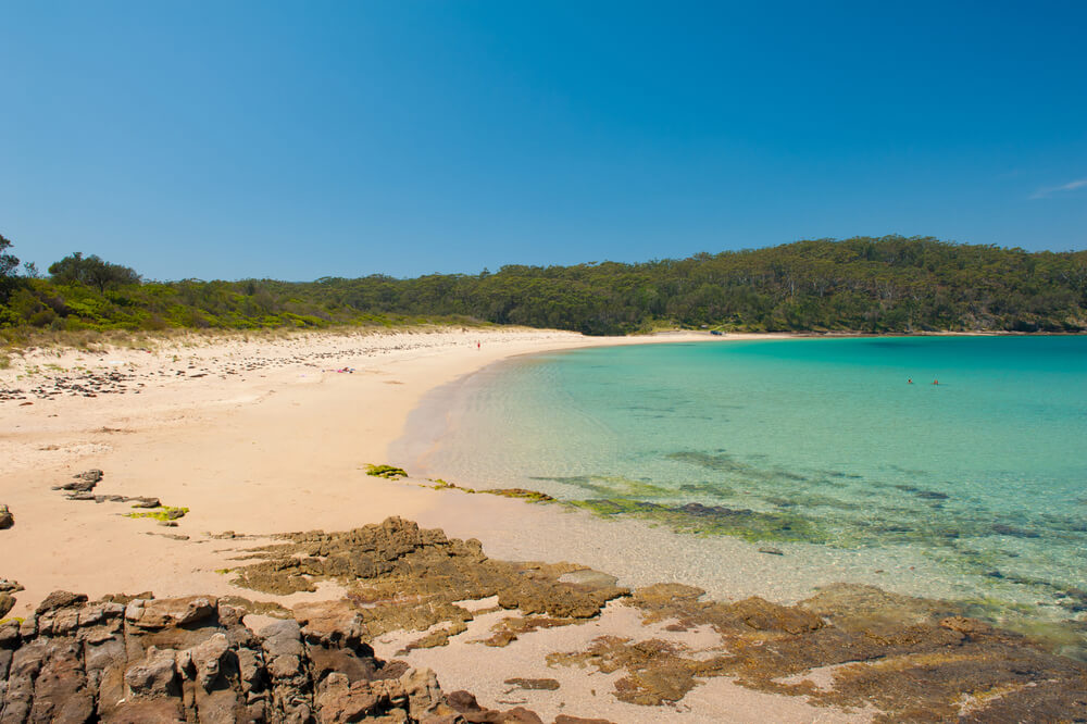 beach with golden sand, aqua water and no one on it.