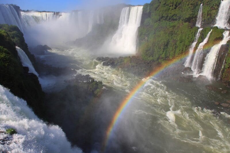 rainbow over the river at bottom of iguazu falls