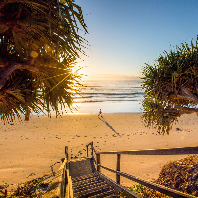 Woman enjoying a morning walk at Diggers Beach, Coffs Harbour.