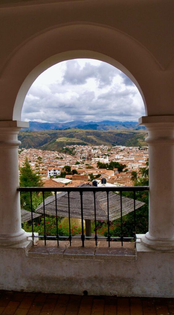 view of village in the middle of an arch way with mountains in the background