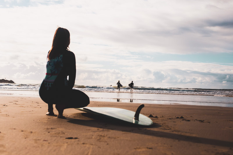 Surfers heading out for a morning surf at Turners Beach, Yamba.