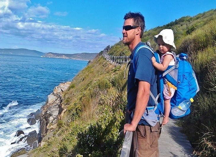 a man carrying a baby on a mountain