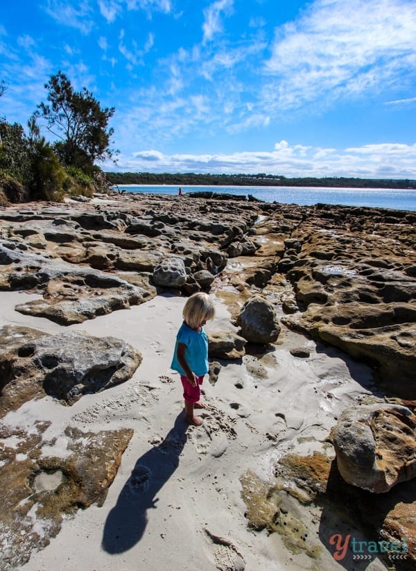 a little girl standing in sand