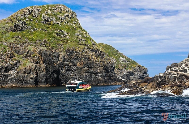 a boat on water next to cliffs