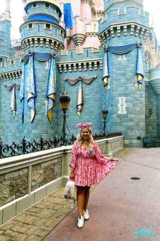 person sitting in front of the castle at Disney World