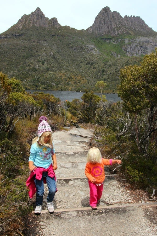 girls walking on a path through trees