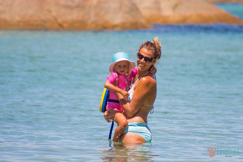 woman holding a child in the water