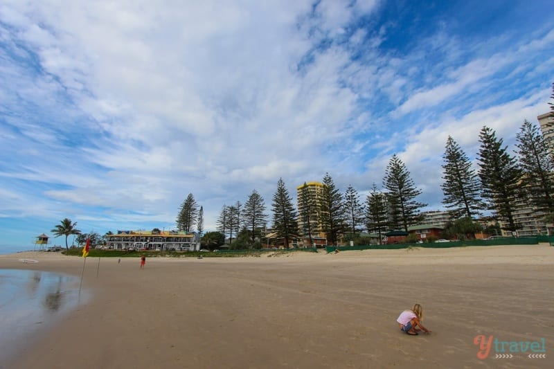 girl playing on sand at Rainbow Bay, Gold Coast, Australia