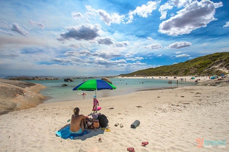 people sitting under umbrella on beach at Greens Pool