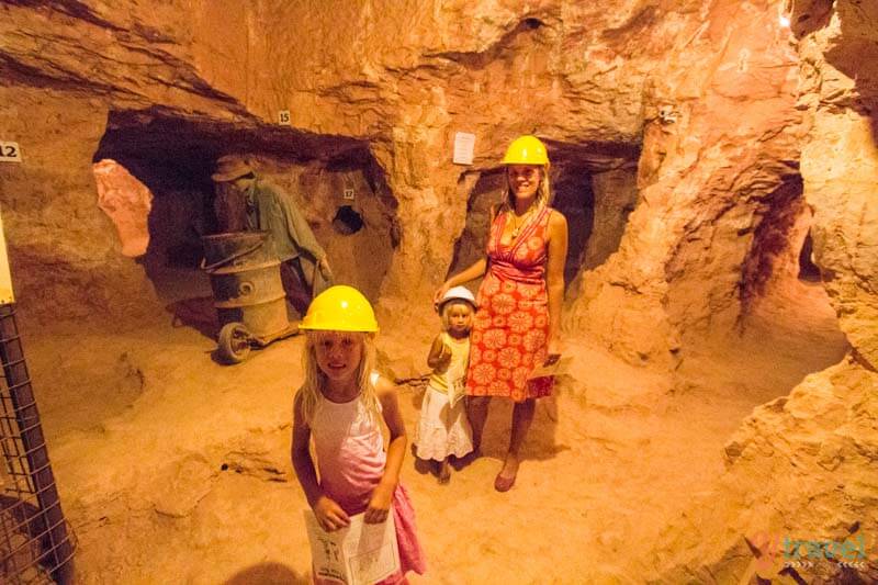 people wearing helmets in a cave