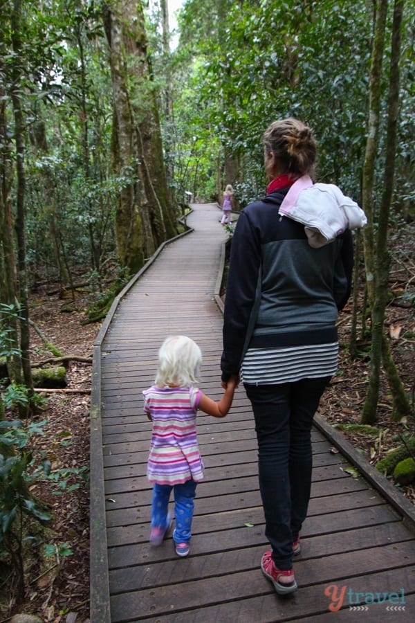 woman holding child hand on boardwalk