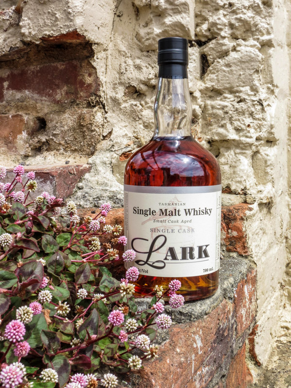 bottle of lark whiskey surrounded by flowers