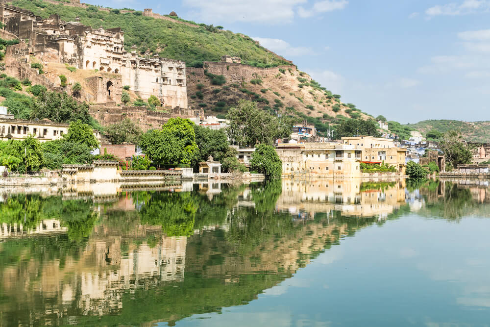 building and trees reflected in nawal sagar lake