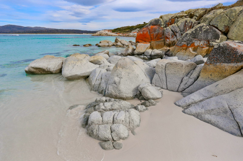 red and white rocks on sandy shore of redbill beach