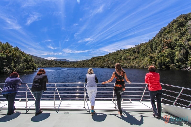 people looking out at water while standing on a bridge