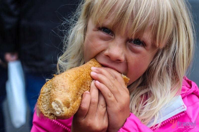 A little girl eating a sandwich