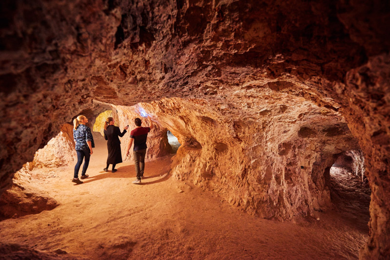 people in opal cave looking at wall