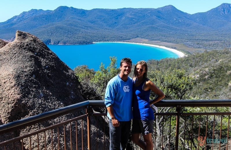 people standing on a lookout above a lake