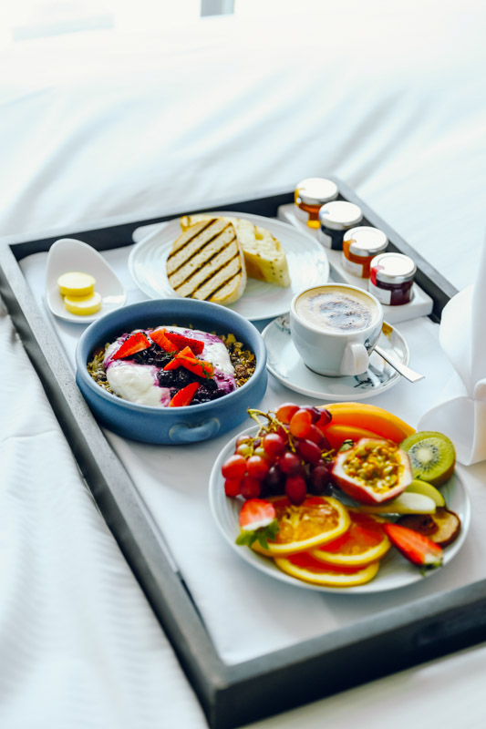 platter filled with fruit, granola and yoghurt and coffee