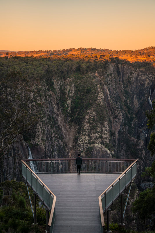 Man watching the sun set over Wollomombi Falls, Walcha.