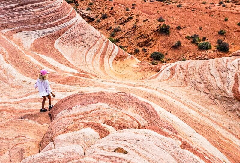 girl walking on pink rocks of Fire wave trail 