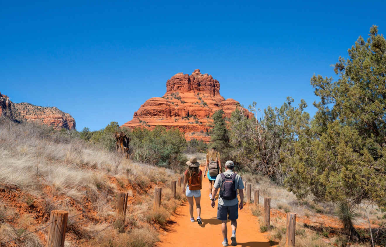 a group of people walking down a dirt road