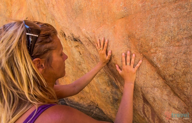 woman placing her hands on a rock