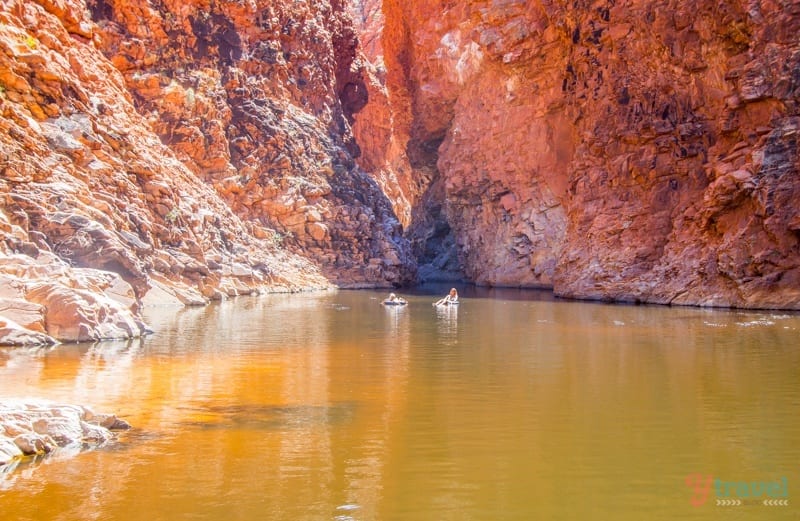 people on tubes on a river going through a canyon