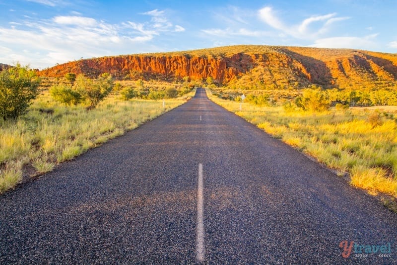 road travelling towards a rocky mountain