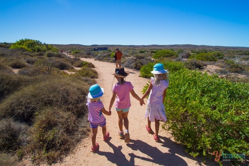 girls walking on a hiking trail holding hands