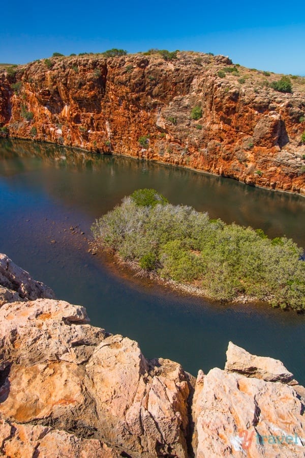 A rocky island in the middle of a body of water