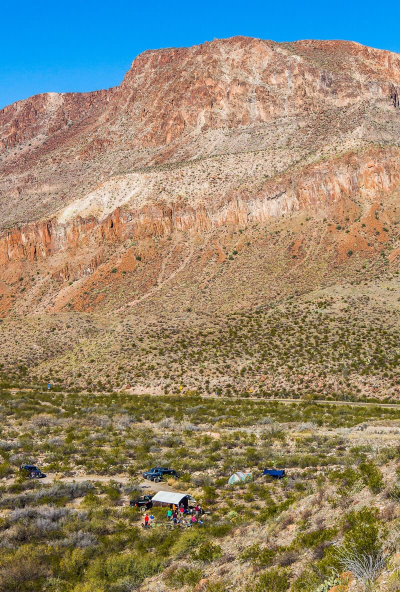 huge, steep pink mountain beside green valley