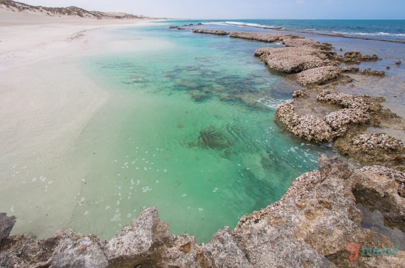 clear blue ocean water surrounded by rocks